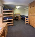 a dorm room with three beds