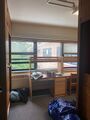 Two desks on the far wall. Closets on the left and right