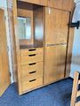 A wooden closet with several drawers and a large sliding door