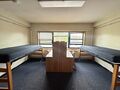a dorm room with two beds and two desks